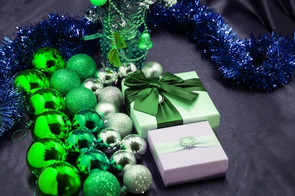 Un regalo con un lazo rojo entre las bolas decorativas se encuentra en un árbol de Navidad — Foto de Stock
