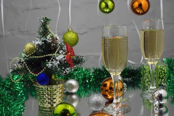 Bodegón de Navidad - Dos copas de champán con decoraciones rojas de Navidad en el árbol de Navidad y fondo amarillo borroso —  Fotos de Stock