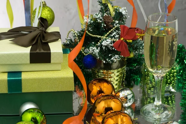 새해와 크리스마스 기념 행사. 황금빛깜빡이는 휴일 배경 위에 샴페인 잔 두 개와 선물 — 스톡 사진