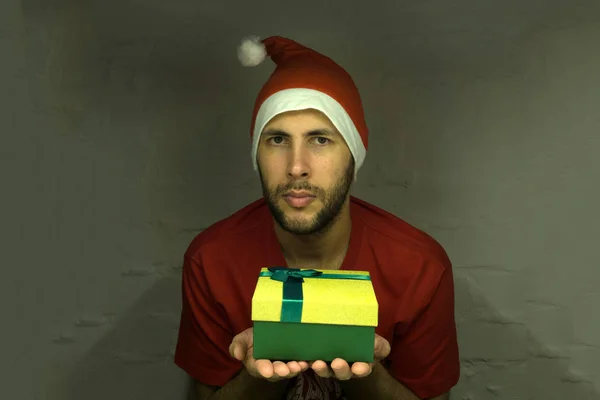 Ragazzo felice con cappello di Babbo Natale in possesso di un regalo — Foto Stock