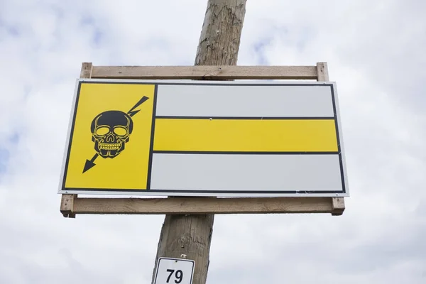 Hochspannungs-Totenkopf mit rotem Blitzstrahl auf weißem Hintergrund Warnschild auf grauem Wandhintergrund montiert — Stockfoto