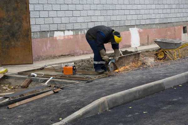adam sıradan giysiler ve atölye kesme metal çalışırken açı değirmenleri ile koruyucu gözlük .