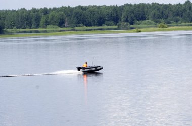 bir tekne motoru ile gri şişirilebilir kauçuk tekne yönetir