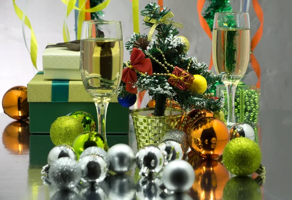 Wszystko dwa kieliszki szampana umieszczone na stole z małych ładnie opakowane pudełko i choinki i światła w tle. Selektywny fokus na pole prezent — Zdjęcie stockowe