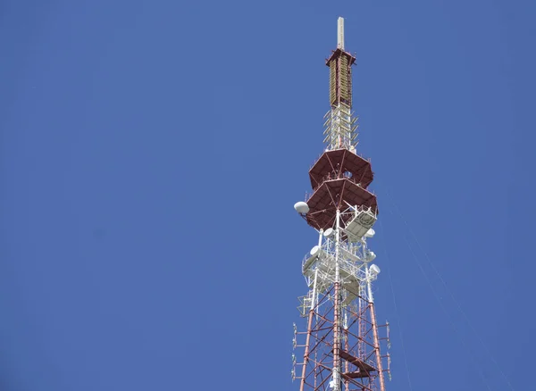 Távközlő torony kék égbolt antennákkal — Stock Fotó