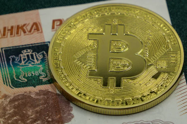 Две символические монеты биткойна на банкнотах по сто долларов. Обмен наличных биткойнов на доллар . — стоковое фото
