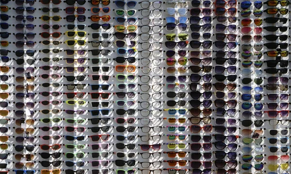 many sunglasses in one place assorted colors .