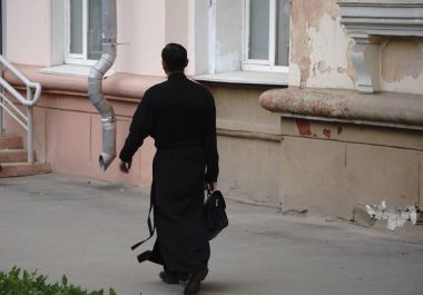Rahip Tanrı'ya dua. Yakışıklı genç Katolik rahip İncil okumak
