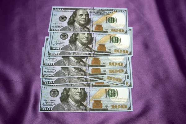 100 dollar biljetten op een paarse achtergrond. — Stockfoto