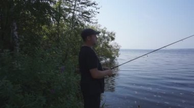 banka. Bir balık adam balıkçı yakalar. Balık tutma, iplik makarası, balık, Breg nehir. -Kırsal bir kaçış kavramı. Balıkçılıkla ilgili makale.