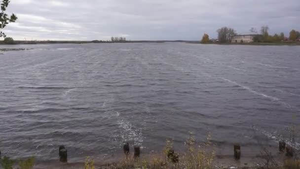 Un vent fort pousse les vagues sur la rivière  .