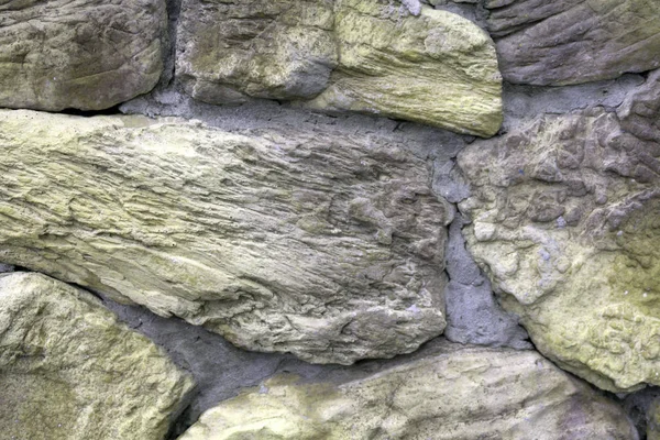 Gran pared de piedras de granito natural de diferente tamaño y textura de color gris en un día de verano  . —  Fotos de Stock