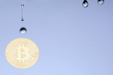 Bitcoins ve büyük bir para destesi yarı yarıya düşen kırmızı grafikte mavi arka plan bulanık bölünmüş. Yukarı alay