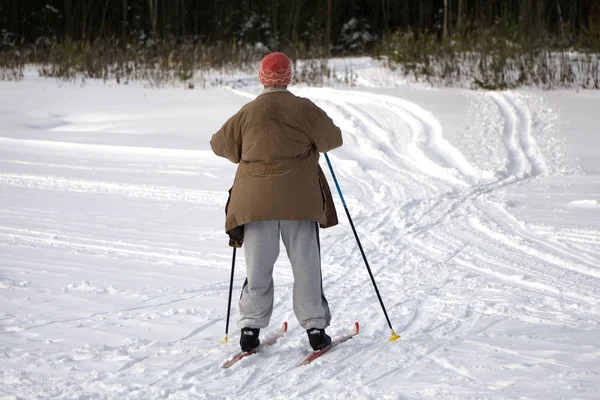 Actieve gelukkig gezond opa, Skiën in het besneeuwde forest op een zonnige winterdag — Stockfoto