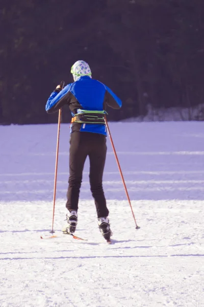 Actieve jongedame skiën in de bergen. De jongen van de vrouwelijke skiër met veiligheidshelm, bril en Polen genieten van zonnige winterdag in Zwitserse Alpen. Ski-wedstrijd voor volwassenen. Winter en sneeuw sport in alpine resort. — Stockfoto