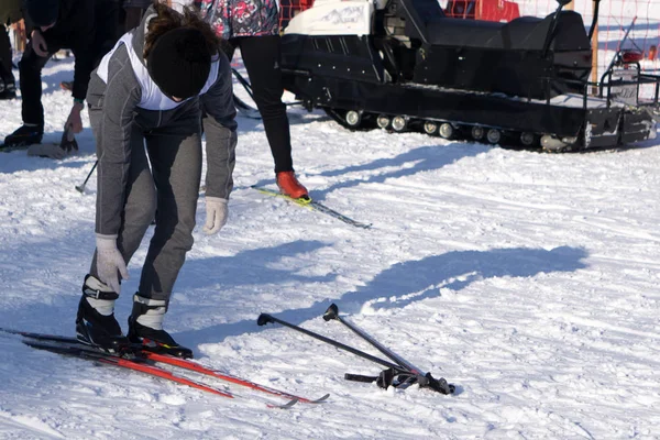 Oranje alpine skischoenen in een ski-mount. Een boot is volledig gefixeerd op ski's, de tweede is niet. — Stockfoto