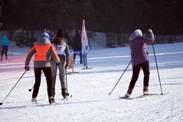 Veel skiërs en snowboarders op een piste in het skigebied. — Stockfoto