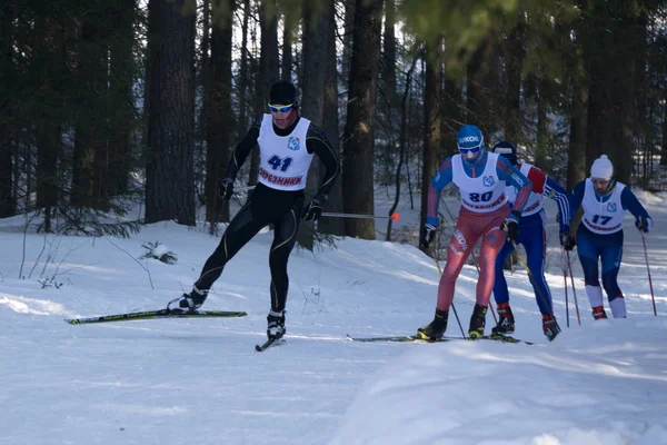 Rusko Berezniki 11 března 2018: skupina mužů sportovci lyžaři v lese volného stylu do kopce během lyžařského závodu mistrovství — Stock fotografie