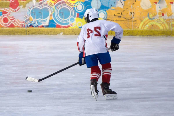 Jégkorong játékos-val egy korongot a jégen, a fűrészlap mozog a jég. — Stock Fotó