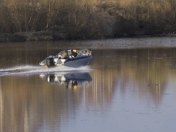 Jongen vissen. een oude man zit in een boot met een hengel. uitzicht vanaf de achterkant. drijvers — Stockfoto