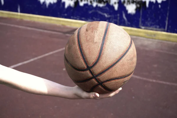Баскетбольный мяч в руке — стоковое фото
