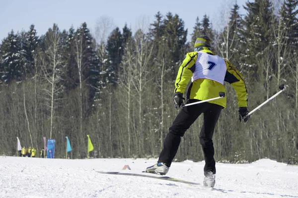Retrato completo de una esquiadora de pie con una pierna levantada en una pista de esquí en un día soleado contra un telesilla. Vacaciones de invierno. Estación de esquí en  . — Foto de Stock