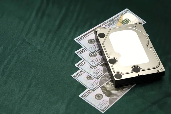 disassembled hard drive on money background. Concept of information safety