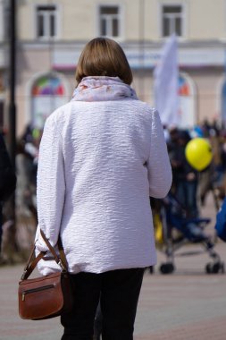 Arkadan Görünüm. Beyaz tuğla bir duvara bir gri yün ceket boy esmer kadın portresi