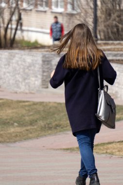 modern siyah ceket ve pantolon giyen bir esmer kız kameranın arkasında gri studio arka plan ayakta pozuyla tam uzunlukta portresi