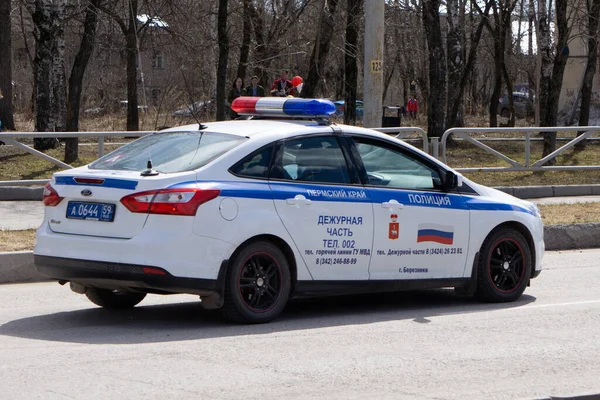 Polis arabasının ışıkları kapalı. Arka planda bir grup polis var. Rusya Berezniki - 01.05.2018