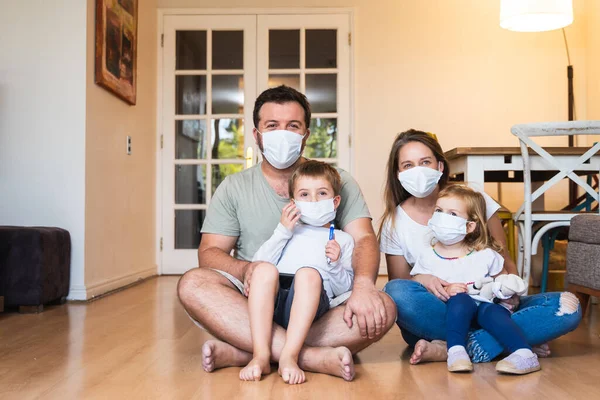 Beautiful young family wearing face masks against coronavirus world pandemic and staying home