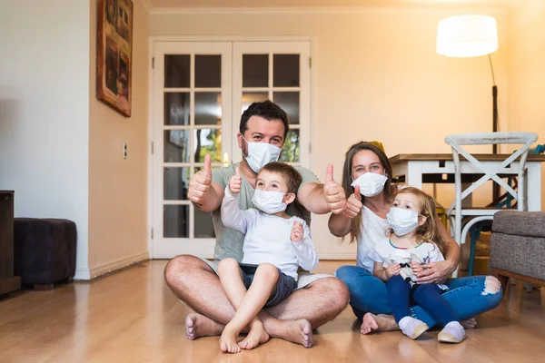 Koronavirüs salgınına karşı maske takıp evde kalan güzel bir aile.