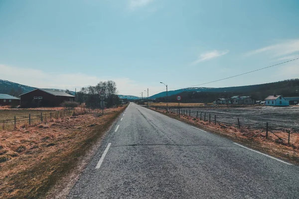 Noruega, estrada em linha reta no campo no norte em um dia ensolarado — Fotografia de Stock
