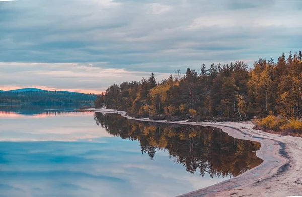 Norte da Finlândia, pôr do sol / nascer do sol no lago com uma água calma e praia de areia — Fotografia de Stock
