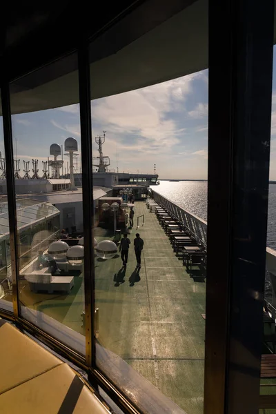 Uit het raam kijken naar mensen die over het dek lopen terwijl de veerboot door de archipel vaart — Stockfoto