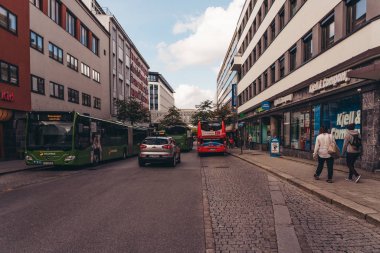 Stavanger Norveç Klubbgata caddesi, otobüsler ve arabalarla aydınlık bir günde insanlar yürüyor.