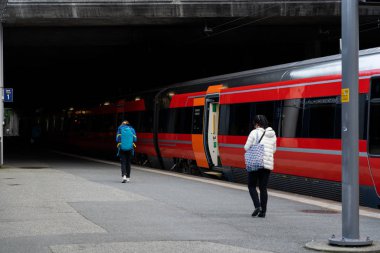 Stavanger Norveçli yolcular tren istasyonuna doğru yürüyorlar.