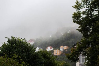 Bergen Norveç 'te yağmurlu ve sisli bir sonbahar gününde Floyfjellet' teki tepedeki evler