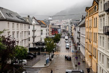 Bergen Norveç Caddesi manzaralı yağmurlu bir Vestre Torggaten ile Floyfjellet sis kaplı