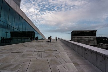Yayın 08.31.2019 Oslo Norveçlileri Opera Binası 'nda yürüyor ve binanın muhteşem mimarisine bakıyor.