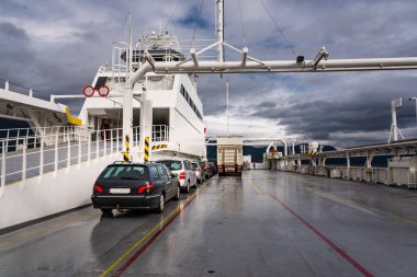 Bir Norveç yol feribotunun güvertesi aydınlık bir yaz gününde fiyortlardan birini geçiyor.