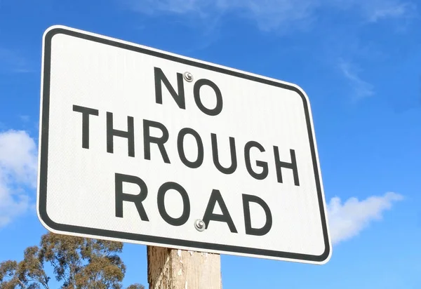 Un cartello in bianco e nero 'No Through Road' contro un cielo blu — Foto Stock