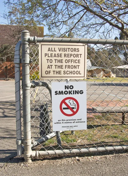 Geen rokers en andere signage in de buurt van de ingang van een basisschool — Stockfoto