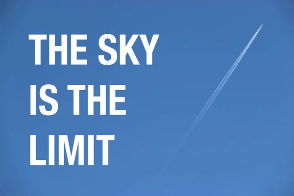 Самолет в голубом небе с положительной поговоркой "Небо - это лимит" — стоковое фото