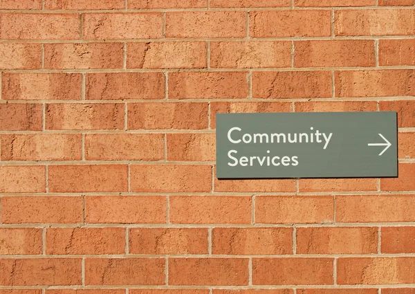 Κοινοτικές υπηρεσίες σημάδι στον τοίχο κόκκινο τούβλο — Φωτογραφία Αρχείου