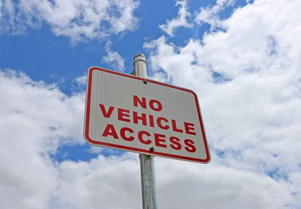 Rosso e bianco Nessun segno di accesso del veicolo in un cielo blu nuvoloso — Foto Stock