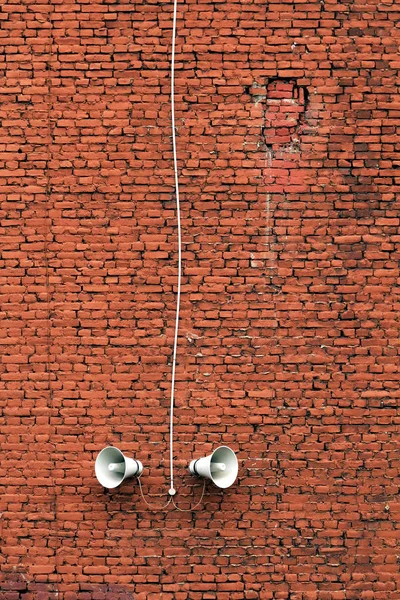 speakers on the brick wall of the old house