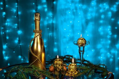 Bir şişe şampanya ve yeni yıl ve üzerinde mavi arka plan Christmas mum