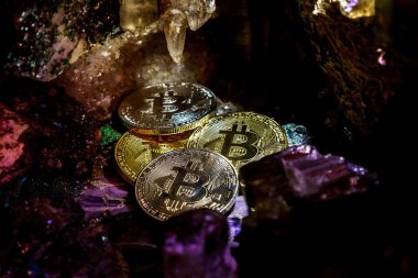 Mücevher taşlarının bir mağarada gümüş ve altın bitcoin