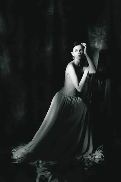 Krásná žena ve večerních šatech na tmavém pozadí — Stock fotografie
